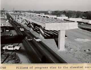 Pillars of progress rise over what was then North Austin -- right by Hancock Center and today's <i>Chronicle</i> offices -- as work begins in the mid-1960s on the I-35 upper deck (completed in 1975). In TxDOT's plans for the I-35 of tomorrow, the upper deck comes down (except for elevated HOV lanes) and the freeway widens, taking out both the Sears auto shop (far left) and the now-moved Academy Sporting Goods (right).