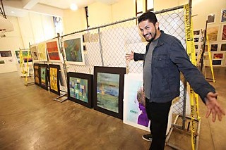 Artist Richard Vasquez offers a sneak preview of his work before last week's opening of the Art From the Streets show at St. David's Trinity Center, held Nov. 6-7. The 18th annual event featured hundreds of art pieces created by people who are homeless.
