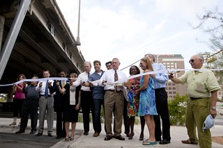 Mayor Lee Leffingwell (center) joined others last week in the official debut of a transformed, formerly dingy parking lot under I-35 between Sixth and Eighth streets, which is now an eye-pleasing, pedestrian-friendly Downtown amenity. 