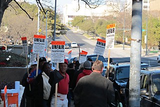 Members of Carpenters Local Union 1266 protest their wage dispute with Bomax outside of the Texas Department of Transportation's Dewitt C. Greer State Highway Building.