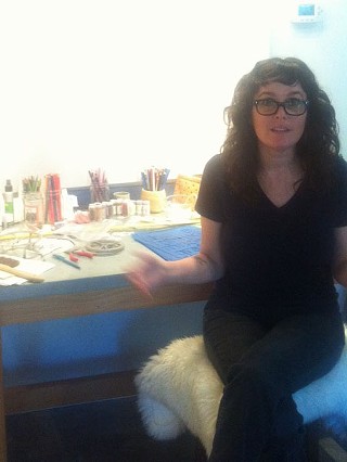 Ewalt, in front of her work table, explains her drawing process.