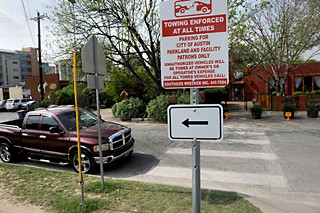 A sign along Toomey Road warns that parking is for park patrons only, but Council will consider a controversial proposal to allow businesses – such as parking-strapped Casa de Luz in the background – to use parking facilities at city parks.