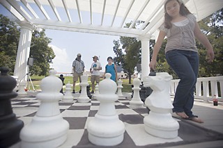 Jessica Amaya, 12, (r) and Cassandra Amaya, 8, play Big Chess on the historic bandstand at Wooldridge Square on Sept. 14 during the park's reopening festivities. The city closed the park a year ago for grounds improvement work.