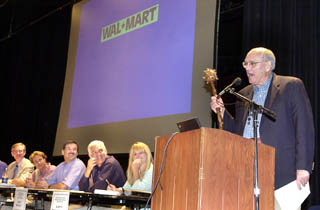 Former Austin mayor Frank Cooksey moderates the Wal-Mart meeting  while holding a medieval mace, jokingly using it to enforce order.