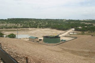 Sewage plant at the foot of West Cypress Hills development under construction, with detention pond at left and dam just beyond it