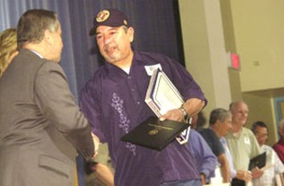 On Nov. 9, the Austin Independent School District 
awarded diplomas to veterans who left school to serve in 
the armed forces, including Albert Chavez Carmona Jr., 
formerly of Johnston High School, who is shown here 
receiving his diploma from AISD Superintendent Pat 
Forgione at Reagan High. Under Texas law, school 
districts may issue diplomas to vets who left high school 
to serve in World War II, the Korean War, or the Vietnam 
War. Since 2002, AISD has given 52 such diplomas.