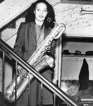 Backstage at the Apollo Theatre, July 1945. Ernie Mae Crafton Miller played baritone sax before trading reeds for the piano.
<br>Photo from ‘Take-Off: American All-Girl Bands During WWII’