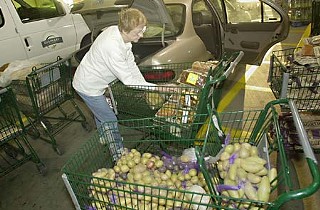 Les Dames d'Escoffier volunteer Sarah Jane English loads up her car with weekly food donations for Caritas and the Saturday Outreach program at University United Methodist Church.
