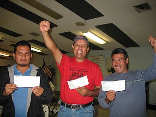 Marcelino Rosas, Ramiro Mora, and Manuel Santiago celebrate their hard-earned wages.