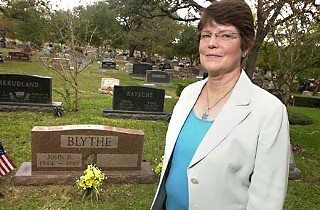 Sharon Blythe stands at the grave site of her husband at Austin Memorial Park Cemetery.