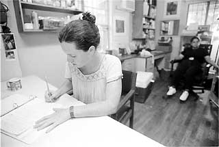 Sarah Miner, one of the Casa Marianella staff, finishes paperwork on a Sunday afternoon.