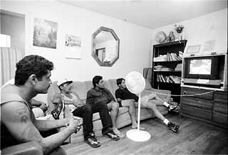 Residents and visitors watch a movie in the living room at Casa Marianella.