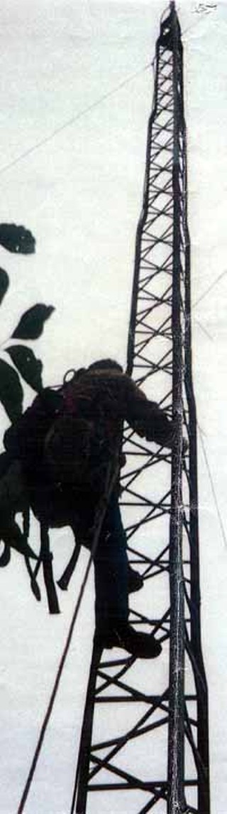 An FCC contractor climbs the Free Radio Austin broadcast tower during the October 10, 2000, raid to begin dismantling the tower.<br><i>Photo courtesy Free Radio Austin</i>