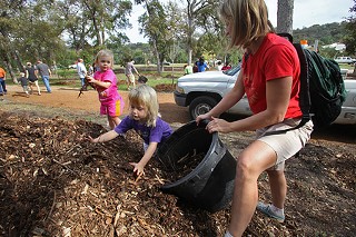 Katharine Beisner and daughters, 4-year-old Ruby and 2-year-old June, dig in at a tree-planting outing at Pease Park on Nov. 14. The weekend effort, organized by Friends of Pease Park, involved planting about 200 trees to replace those damaged or lost to a summer windstorm.