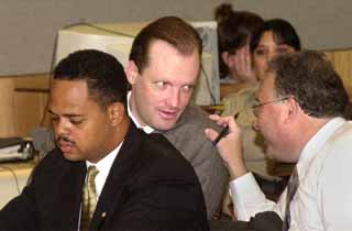 Michael Scott (middle) confers with his defense attorneys.