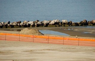Looking west, from the atop the pier at Grand Isle State Park. The two blue circles in the dark square of tarp are wading pools used for cleaning.