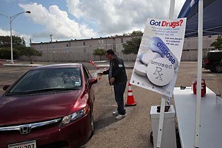 A driver passes off a bag of drugs to Paul Nadeau of the U.S. Drug Enforcement Agency as part of a national prescription drug take-back day, held Sept. 25
in Austin
at Cornerstone Church. Residents were urged to safely dispose of their unused meds to prevent them from tainting the water supply and God knows
what else.