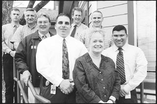 APD and Travis County sheriff's mental health officers (clockwise from front) Dawn Beam, Sam Tannous, James Lumpkin, Mike Sorenson, Joel Pridgeon, Jeff Hampton, Art Fortune, and Pete Garza, outside the MHMR Psychiatric Emergency Services Building at 56 East Ave.