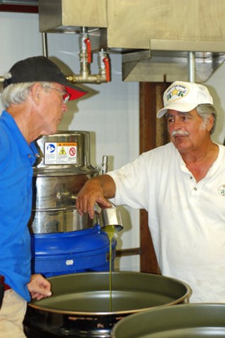 Jerry Farrell (r) and Jim Henry (l) press Farrell's 2010 olive oil.