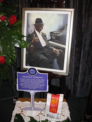 Flanking Pinetop's casket, a portrait by Diane Russell, his marker from the Blues Highway, and his ever-present McDonald's bag