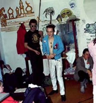 Strummer and Ely (kneeling) backstage at the Dillo