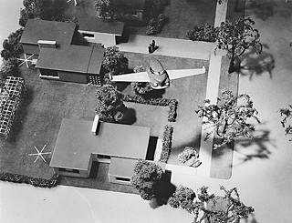 Aerial view of Bel Geddes' flying car over model neighborhood, ca. 1945