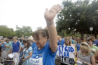 Dressed in blue, hundreds of pro-life supporters pray during a rally outside the Capitol Tuesday night; meanwhile, an orange-attired, pro-choice crowd marched down Congress. See SB 1/HB 2: How a Lie Becomes a Law, p.12.