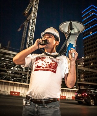 A construction worker rallies the troops at a wage protest in June at the JW Marriott construction site