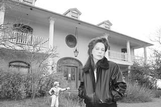 Melinda Ballard in front of her 12,000-square-foot replica of Tara, the <i>Gone With the Wind</i> mansion, in Dripping Springs. The house is now completely uninhabitable, destroyed by mold.