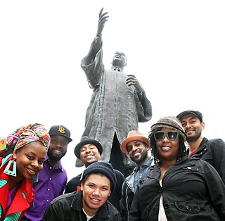 All Rise: (l-r) Tiger Lily, Bavu Blakes, Da'Shade Moonbeam (back), DJ Charlie (front), Chaka Mpeanaji, Queen Deelah, and DJ Chorizo Funk at UT's MLK statue