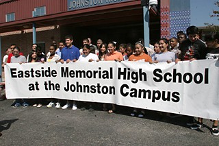 Students hold a banner in a ceremony changing the name Johnston High School to Eastside Memorial High School