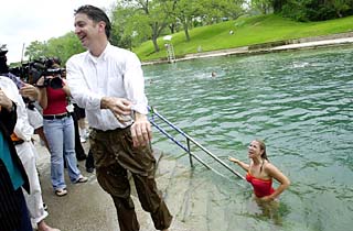 City Manager Toby Futrell, properly attired for a dip in Barton Springs, emerges from the water behind a fully clothed Will Wynn.