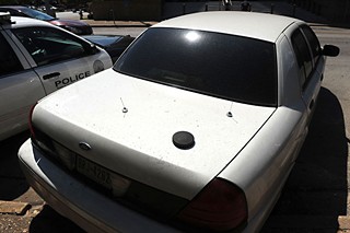 A possible IMSI catcher sits atop an unmarked car.