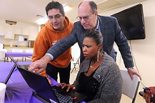 AISD employees Rogelio Guzman (l) and Les Ready help AISD parent Netta Pierre set up her AISD account at Austin Pathways/Digital Inclusion's Tech Feria.