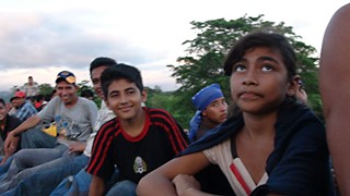 Migrants sit atop the freight train in Mexico, embarking on their journey to the U.S.