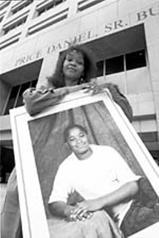 Barbara Taft, a supporter of Lacresha Murray, holds a picture of Murray at a 1998 protest.
