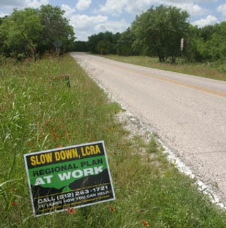 Hamilton Pool Road:
<br>

Hamilton Pool Road would require extensive improvements to accommodate the tens of thousands of vehicle trips generated by new development in the area. Here, one of many signs dotting the roadway cautions the LCRA to delay action on a water pipeline until the completion of a regional plan. Other signs championed the proposed water line.