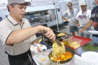 Paul Kuzmich prepares a shrimp pasta lunch entrée on the Austin Studios set of a Mike Judge production.