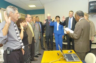 County Judge Sam Biscoe swears in the nine new members of the Travis Co. Hospital District Board of Managers.