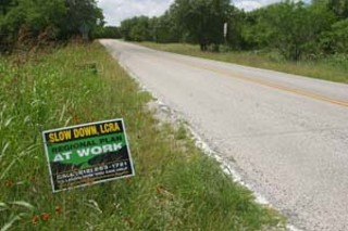 This sign on Hamilton Pool Road calls for the LCRA
to delay its water pipeline decision until a regional plan
is in place. If growth continues without a plan, the
eastern segment of this little two-lane country road
could see 20,000 car trips per day by 2030 (up from
6,500 today) and would require widening to four lanes,
according to Texas Department of Transportation
reports.