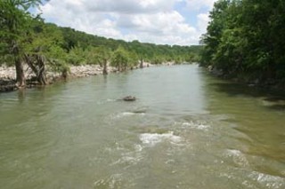 This view of the Pedernales River from Hammett's
Crossing, a quaint low-water bridge constructed in the
mid-Twenties, could change drastically over the next
10 to 30 years. The bridge disappeared under water
during heavy rains in November and could disappear
altogether if new development and traffic continue
pushing westward.