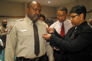 Greg Hamilton's eyes well with tears on Monday as
he is sworn in as Travis County's first black sheriff