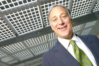 Greater Austin Chamber of Commerce President (and
former Austin Mayor) Kirk Watson, shown here with
some city-of-Austin-owned solar panels, is pushing to
bring clean energy business to town.