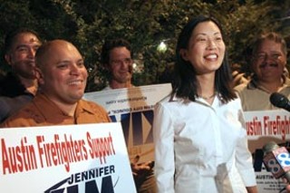 Jennifer Kim talks to the TV after learning of her victory. At her side is firefighters union President Mike Martinez; the firefighters' endorsement was crucial to her win.