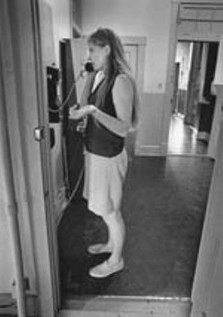 Women's lib activist Judy Smith using the pay phone at 
the University Y just down the hall from <i>The Rag</i> 
to counsel someone about birth control and abortion 
options. Smith ran a clandestine birth control and 
abortion information center out of a cubicle at <i>The 
Rag</i>.