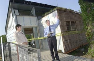 UT Architecture School Dean Fritz Steiner (right) reads
a proclamation from Mayor Will Wynn declaring Tuesday
UT SolarD Day, following a ribbon-cutting ceremony at
UT’s nearly complete, 800-square-foot solar-powered
house, designed and built by 40 undergraduate and
graduate students for the national Solar Decathlon
competition. In less than a month, the house, known as
the SNAP because its four modules are designed to snap
together on site, will be disassembled and re-erected on
the National Mall in Washington, D.C., where it will
compete with 17 other homes in the areas of energy
efficiency, ingenuity, and architecture. Students hope to
transform the contemporary residential-home-building
industry, which they say accounts for the highest energy
consumption and most environmental damage of any
industry in the country, by interjecting much-needed
diversity, economic viability, and environmental
sustainability; and in the process, change the public
from energy consumers to energy producers, according
to the team’s design philosophy. The house’s use of
prefabricated, structurally insulated zinc panels makes it
relatively easy to transport and put together, as well as
energy efficient. Upon its return to Austin, SNAP will be
donated to a local nonprofit. For more information, see
<a href=http://www.utsolard.org
target=blank><b>www.utsolard.org</b></a>. <br>
– <i>Daniel Mottola</i>