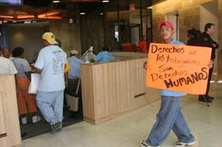 About 50 people showed up at last Thursday’s council meeting in support of local day laborers, who were appealing to council members for support in establishing a “safe, dignified hiring space” on the grounds of Home Depot at the corner of I-35 and St. John’s. This worker’s sign says, “Workers’ rights are human rights.”
