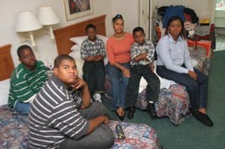 New Orleans native Jaren Diaz (left) and his family occupy three rooms at the La Quinta Inn on East 11th Street. His mother, Donna (third from right), says she would like to stay in Austin if she can find an apartment for her and Jaren before FEMA stops paying for Katrina and Rita evacuees to stay in hotels and motels. The agency extended the cutoff deadline Tuesday from Dec. 1 to Jan 7.