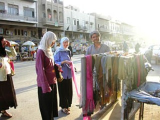 Female members of the Christian Peacemaker Teams shopping at the street vendors in Karrada, Iraq. They are wearing now-typical Iraqi women's garb, so as not to stand
out.