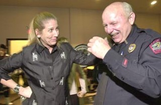 City Manager Toby Futrell, who later described APD Chief
Stan Knee as possessing a wry and dangerous sense of
humor, shares a laugh with the chief. A community
reception was held Tuesday evening at Cornerstone
Church, where hundreds said farewell to Knee, stepping
down from APD to accept a position training police in
Afghanistan. For more on the reception and Knee's
departure, see APD's Stan Knee Goes East
<i>Way</i> East.